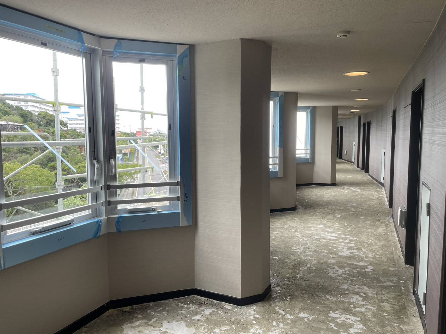 マンション共用廊下の窓に養生をして施工している様子